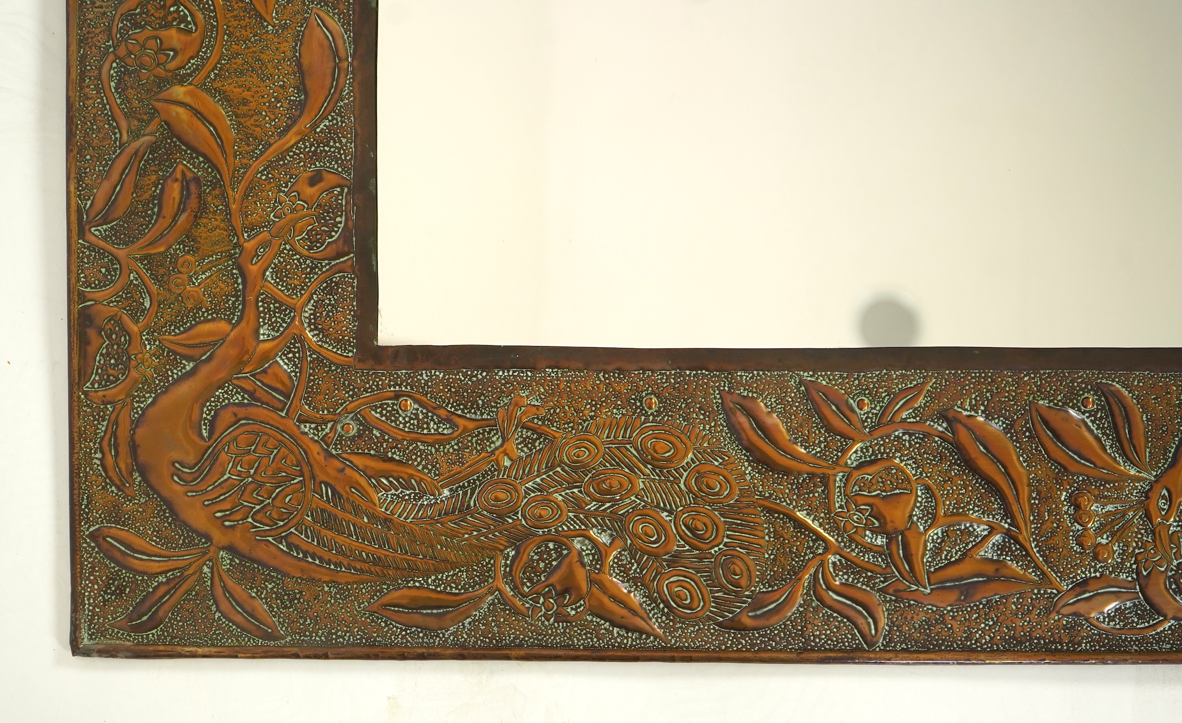 An Arts and Crafts embossed copper mirror, manner of Talwin Morris, Glasgow School